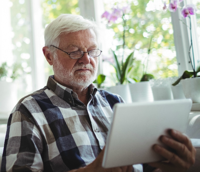 Photo of an older man using a tablet device
